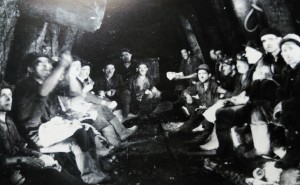 En la fotografia veiem un grup de miners en la pausa per dinar. Extreta del Relleu fotografic de les Mines del Berguedà