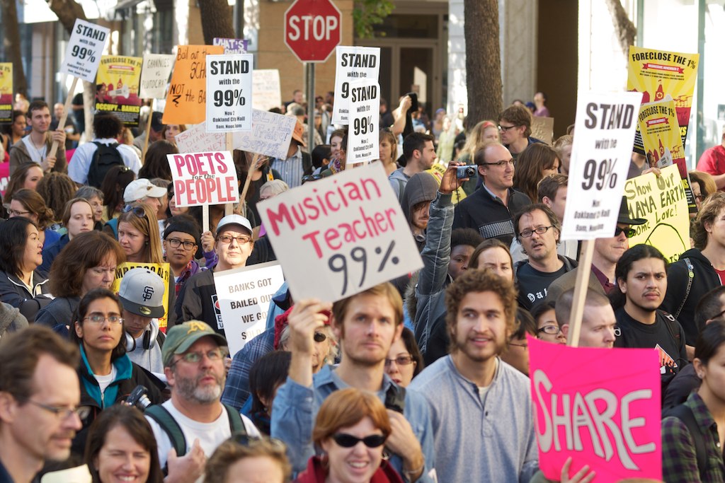 Estatunidencs d'Oakland fent servir el lema "We are the 99%" (aparegut el 2011), que denunciava la gran desigualtat econòmica i social actual. Font: Viquipèdia